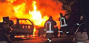 Le auto in fiamme dopo i disordini di Bergamo. Ansa