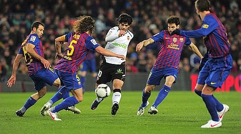 Banega (al centro) durante Barcellona-Valencia di Copa del Rey. Afp