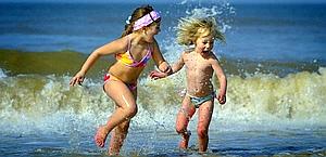 Due bambini giocano al mare. Epa