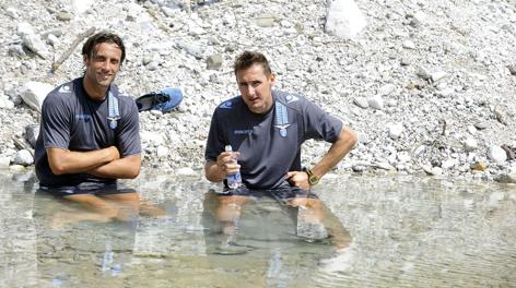 Stefano Mauri (sin.) si rinfresca nel fiume con Miroslav Klose. LaPresse