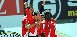 Gaetano Caridi abbracciato dai compagni dopo il gol. LaPresse