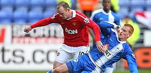Wayne Rooney e Ben Watson del Wigan. LaPresse 