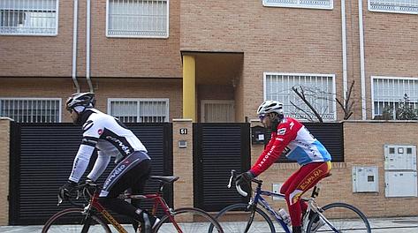 Due cicloamatori passano davanti alla casa di Contador