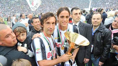 Andrea Pirlo e Alessandro Matri col trofeo che spetta ai vincitori dello scudetto. Ansa
