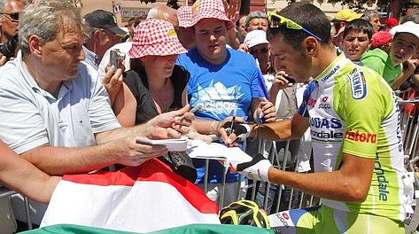 Vincenzo Nibali firma autografi alla partenza. Reuters
