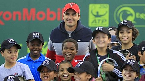 Roger Federer, 31 anni, circondato dai ragazzi del Qatar Open. Reuters