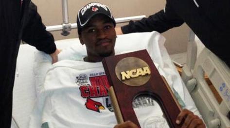 Kevin Ware nel letto di ospedale col trofeo che gli hanno portato i compagni. Reuters