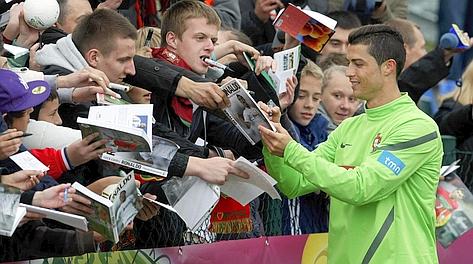Cristiano Ronaldo firma autografi durante un allenamento. Reuters