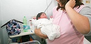 Una madre culla il suo neonato. Ansa