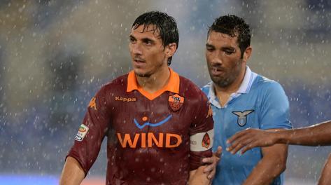 Nicolas Burdisso sotto la pioggia con Andre Dias durante un derby Roma-Lazio di campionato. Ansa