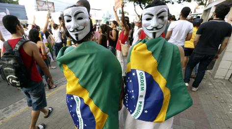 Manifestanti mascherati a Rio de Janeiro. Reuters