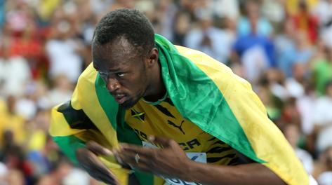 Usai Bolt esulta con la bandiera della Giamaica. Afp