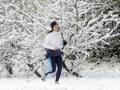 Jogging nel parco sud di Milano imbiancato da una spruzzata di neve (Ansa)