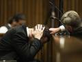 Oscar Pistorius si copre le orecchie durante una testimonianza in aula. Afp