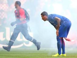 Mario Mandzukic getta fuori dal campo uno dei fumogeni lanciati dai suoi “tifosi”.Getty