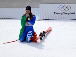 Sofia Goggia in ginocchio davanti al podio olimpico. Getty