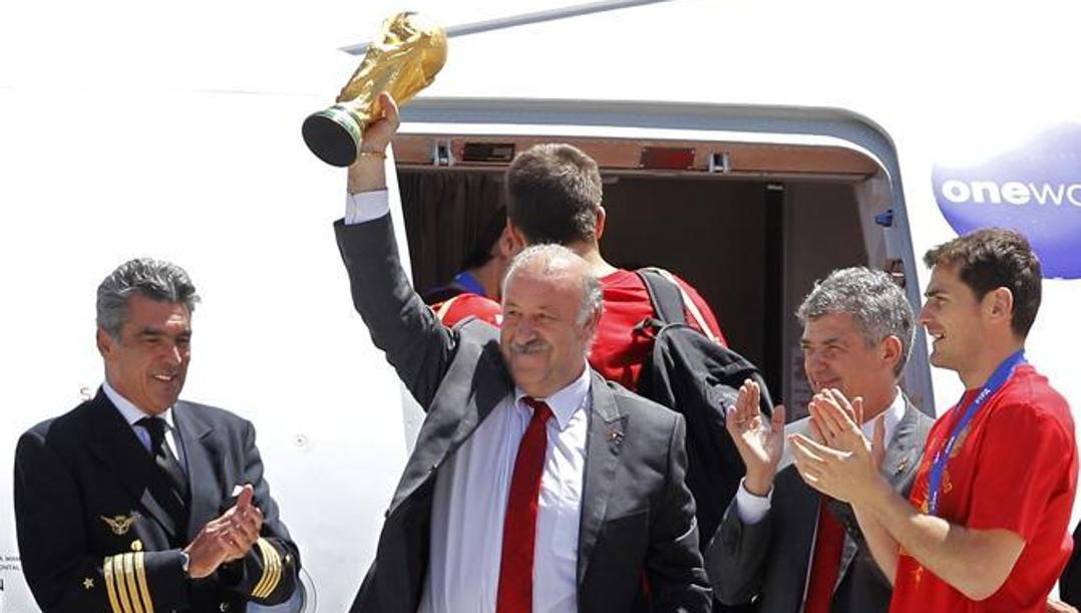 Vicente Del Bosque, al ritorno dal mondiale sudafricano del 2010, alza la coppa conquistata dalla sua Spagna appena sceso dall'aereo.  