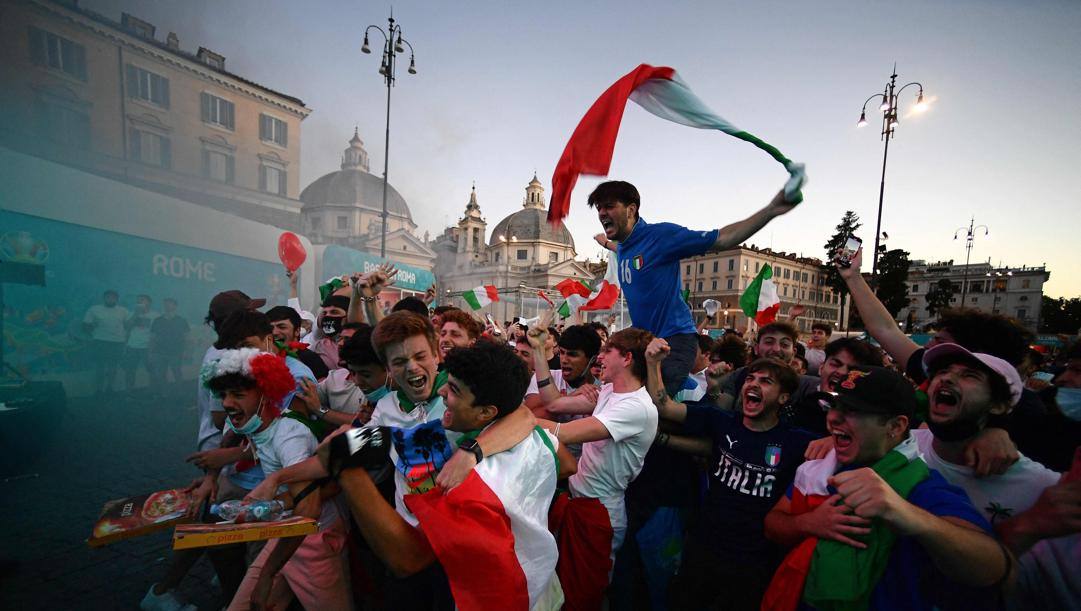 Abbracci tra tifosi azzurri a Piazza del Popolo durante Italia-Austria. Afp 
