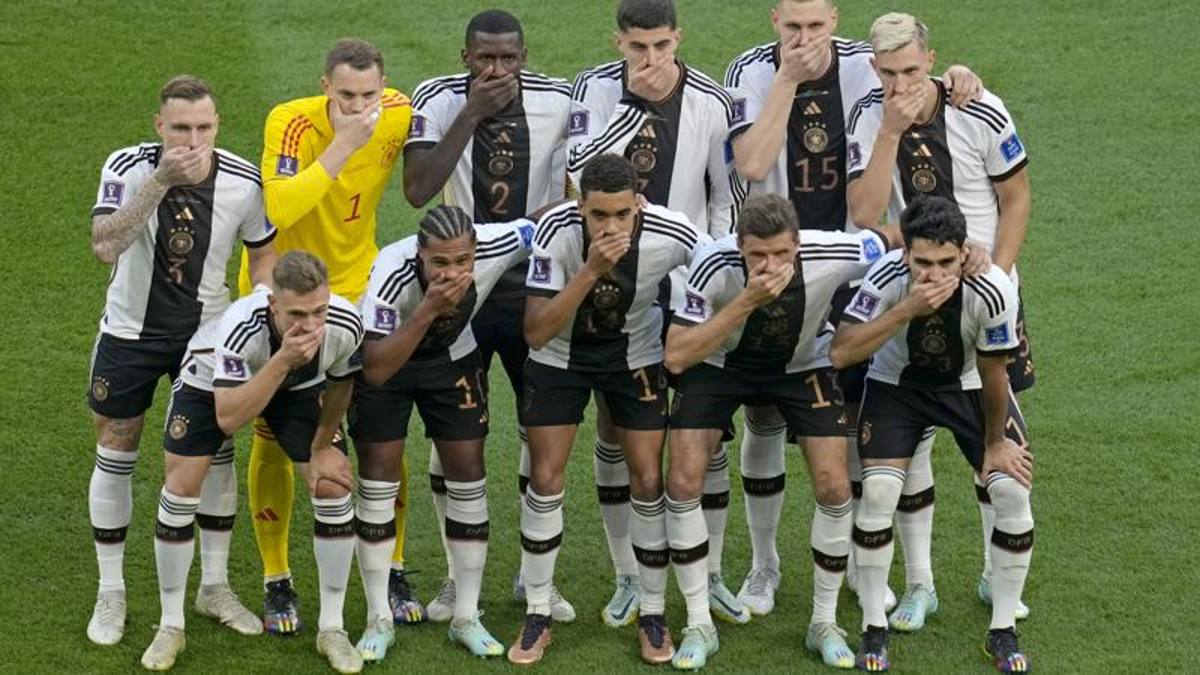 Neuer without the rainbow band.  But Germany protests: players with their hands over their mouths