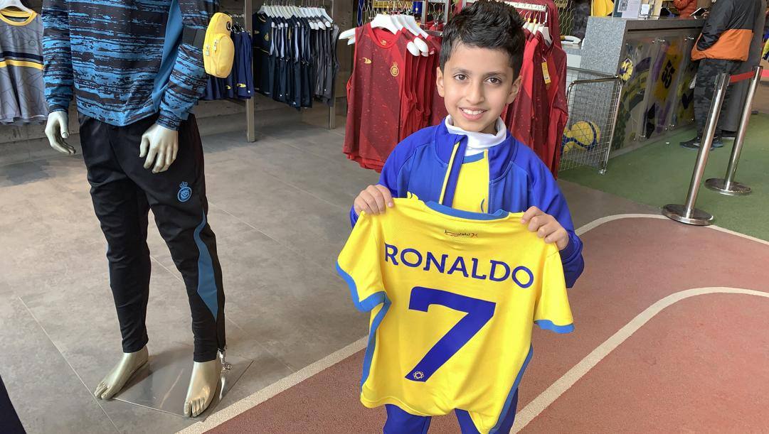 Un piccolo tifoso compra la maglia di Ronaldo dell'Al Nassr. Afp 
