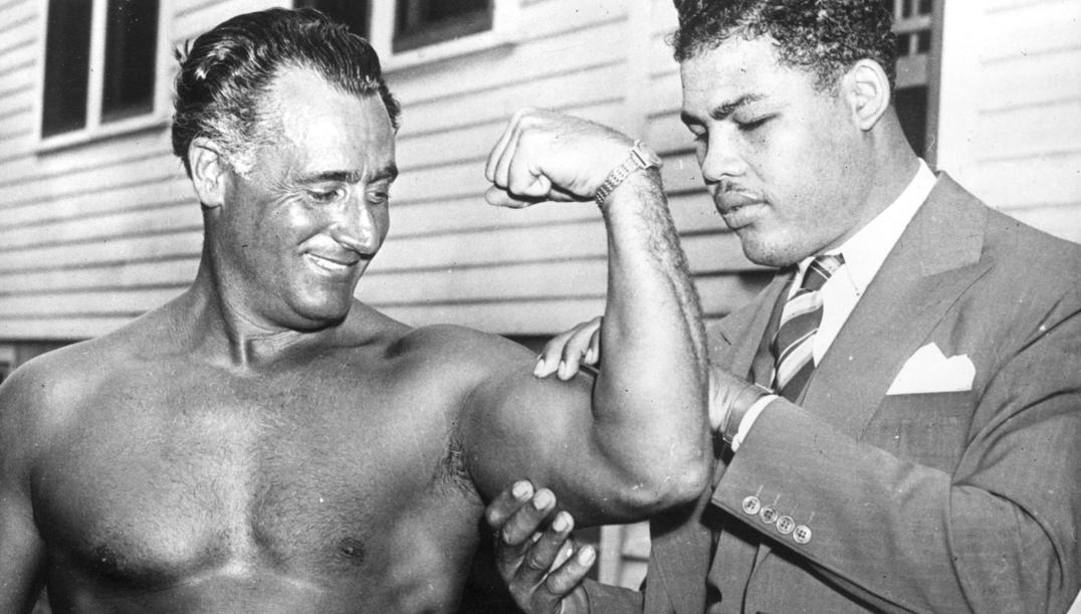 Il campione di boxe Joe Louis tasta il bicipite di Charles Atlas. Getty 